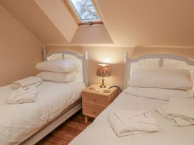 A bedroom with two beds and a lamp on a bedside table at Golden Valley View in Stroud