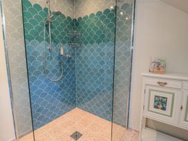 A shower with patterned tiles and a cabinet at Golden Valley View in Stroud