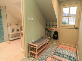 A hallway with a coat rack and bench at Golden Valley View in Stroud
