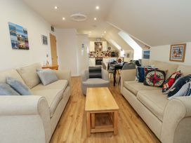 A living room with a sofa, coffee table and open kitchen at Flat 7 Weymouth