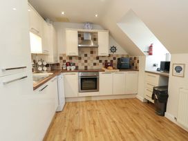 A kitchen with cabinets and appliances at Flat 7 Weymouth