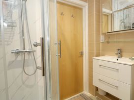 A bathroom featuring a shower, sink, and mirror at Flat 7 Weymouth