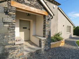 The entrance with a stone wall and front door at Low House Cottage Ayside near Newby Bridge