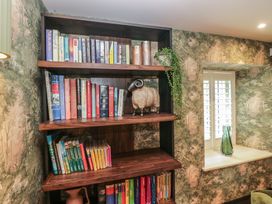 A bookshelf with books and decorative items at Low House Cottage Ayside near Newby Bridge