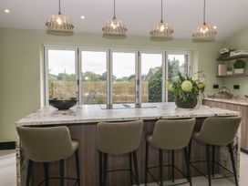 A kitchen with a counter and bar stools at Low House Cottage Ayside near Newby Bridge