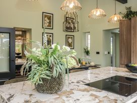 A kitchen with an island and decorative plants at Low House Cottage Ayside near Newby Bridge