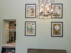 A living room with a chandelier and framed artwork at Low House Cottage Ayside near Newby Bridge