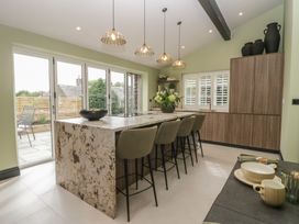 A kitchen with an island and chairs at Low House Cottage Ayside near Newby Bridge