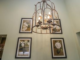 A chandelier and framed artwork on a wall at Low House Cottage Ayside near Newby Bridge
