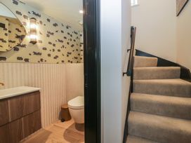 A bathroom with a sink and toilet and a staircase at Low House Cottage Ayside near Newby Bridge