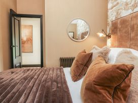 A bedroom with a bed and mirror at Low House Cottage Ayside near Newby Bridge