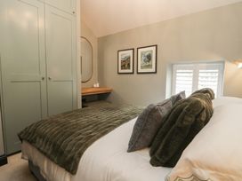 A bedroom with a bed and a wardrobe at Low House Cottage Ayside near Newby Bridge