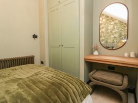 A bedroom with a bed and a mirror at Low House Cottage Ayside near Newby Bridge
