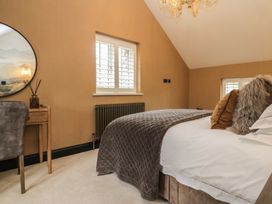 A bedroom with a bed, chair, and mirror at Low House Cottage Ayside near Newby Bridge