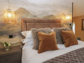 A bedroom with a bed and lamps at Low House Cottage Ayside near Newby Bridge