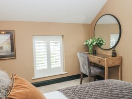 A bedroom with a desk and flowers at Low House Cottage Ayside near Newby Bridge