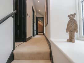 A hallway with a staircase and a bear figure at Low House Cottage Ayside near Newby Bridge