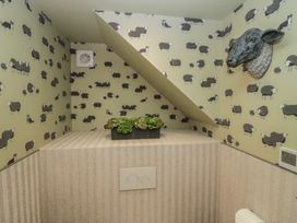 A bathroom with sheep wallpaper and a plant decoration at Low House Cottage Ayside near Newby Bridge