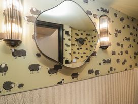 A bathroom with sheep wallpaper and a mirror at Low House Cottage Ayside near Newby Bridge