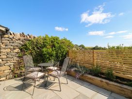 An outdoor seating area with table and chairs at Low House Cottage Ayside near Newby Bridge
