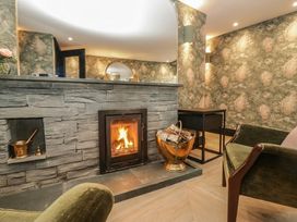 A living room with a fireplace and seating area at Low House Cottage Ayside near Newby Bridge