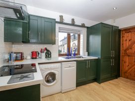 A kitchen with cabinets, sink, dishwasher, and washing machine at The Wren's Nest in Ross-on-Wye