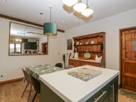 A kitchen with a dining table and wooden cabinet at The Wren's Nest in Ross-on-Wye