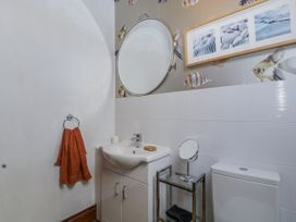 A bathroom with a sink, toilet, and mirror at The Wren's Nest in Ross-on-Wye