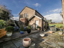 A garden area with a stone patio and various plant pots at The Wren's Nest in Ross-on-Wye