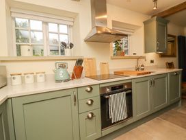 A kitchen with cabinets and a sink at Bridge House Cottage in Burn Bridge near Harrogate