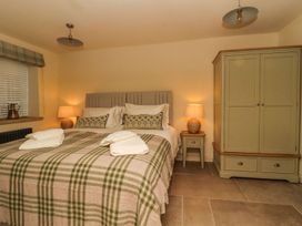 A bedroom with a bed and wardrobe at Bridge House Cottage Burn Bridge near Harrogate