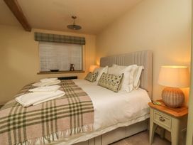 A bedroom with a bed and nightstand at Bridge House Cottage Burn Bridge near Harrogate