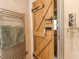 A bathroom with a towel radiator and wooden door at Bridge House Cottage Burn Bridge near Harrogate