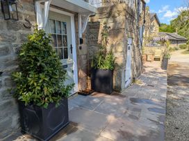 An entrance with planters and a bench at Bridge House Cottage, Burn Bridge near Harrogate