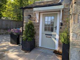 An entrance door with plant pots at Bridge House Cottage in Burn Bridge near Harrogate