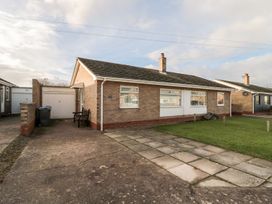 A bungalow with a driveway and garage at Megstone Chathill