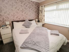 A bedroom with a bed and nightstands at Megstone in Chathill