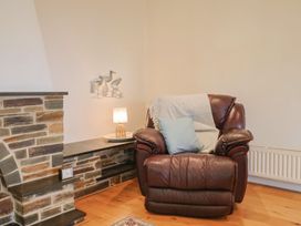 A living room with an armchair and a lamp at Hawksdown Lyme Regis