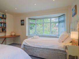 A bedroom with two beds and a bookshelf at Hawksdown in Lyme Regis