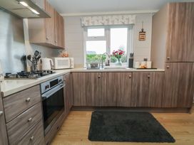 A kitchen with a sink and appliances at Holly Lodge in Lloc near Caerwys