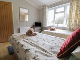A bedroom with twin beds and a tv at Holly Lodge in Lloc near Caerwys