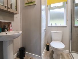 A bathroom with a sink and toilet at Holly Lodge in Lloc near Caerwys