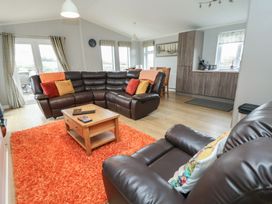 A living room with sofas and a coffee table at Pine Lodge in Lloc near Caerwys