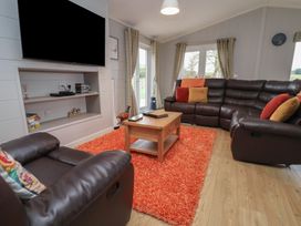 A living room with a sofa and television at Pine Lodge Lloc near Caerwys