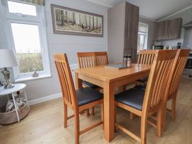 A dining room with a table and chairs at Pine Lodge in Lloc near Caerwys