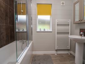 A bathroom with a bathtub and sink at Pine Lodge in Lloc near Caerwys