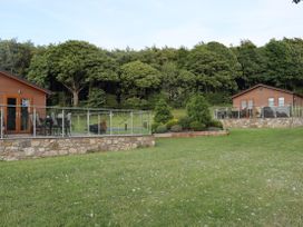 An outdoor area with lodges and seating at Pine Lodge in Lloc near Caerwys