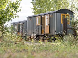Two shepherd's huts with steps and garden benches at No 2 The Parkland Upton Warren