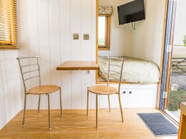 A sitting room with chairs and a table at No 2 The Parkland in Upton Warren