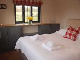 A bedroom with a bed and towels on top at The Lodge in Upton Warren